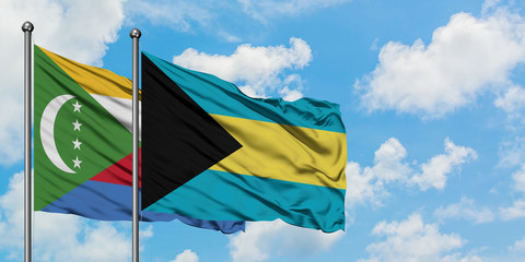 Comoros and Bahamas flag waving in the wind against white cloudy blue sky together. Diplomacy concept, international relations.