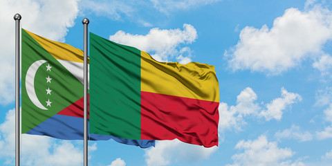 Comoros and Benin flag waving in the wind against white cloudy blue sky together. Diplomacy concept, international relations.