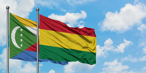 Comoros and Bolivia flag waving in the wind against white cloudy blue sky together. Diplomacy concept, international relations.