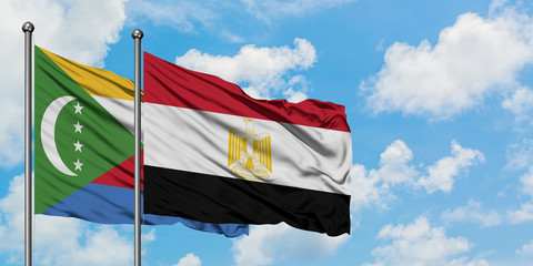 Comoros and Egypt flag waving in the wind against white cloudy blue sky together. Diplomacy concept, international relations.