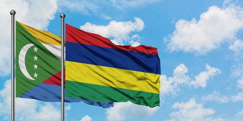 Comoros and Mauritius flag waving in the wind against white cloudy blue sky together. Diplomacy concept, international relations.