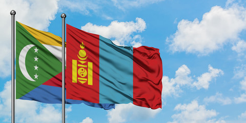 Comoros and Mongolia flag waving in the wind against white cloudy blue sky together. Diplomacy concept, international relations.