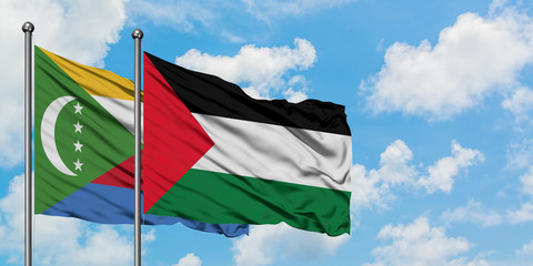Comoros and Palestine flag waving in the wind against white cloudy blue sky together. Diplomacy concept, international relations.