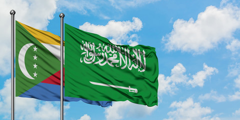 Comoros and Saudi Arabia flag waving in the wind against white cloudy blue sky together. Diplomacy concept, international relations.