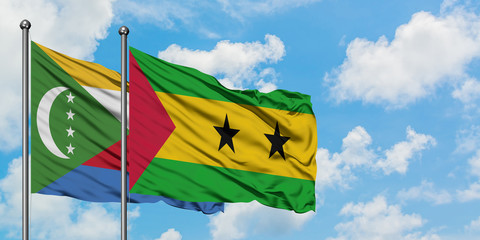Comoros and Sao Tome And Principe flag waving in the wind against white cloudy blue sky together. Diplomacy concept, international relations.