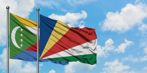 Comoros and Seychelles flag waving in the wind against white cloudy blue sky together. Diplomacy concept, international relations.