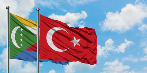 Comoros and Turkey flag waving in the wind against white cloudy blue sky together. Diplomacy concept, international relations.