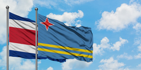 Costa Rica and Aruba flag waving in the wind against white cloudy blue sky together. Diplomacy concept, international relations.