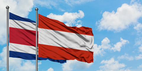 Costa Rica and Austria flag waving in the wind against white cloudy blue sky together. Diplomacy concept, international relations.
