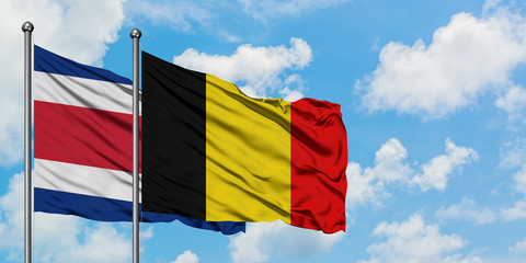 Costa Rica and Belgium flag waving in the wind against white cloudy blue sky together. Diplomacy concept, international relations.