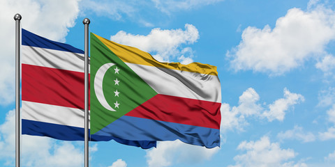 Costa Rica and Comoros flag waving in the wind against white cloudy blue sky together. Diplomacy concept, international relations.