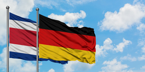 Costa Rica and Germany flag waving in the wind against white cloudy blue sky together. Diplomacy concept, international relations.