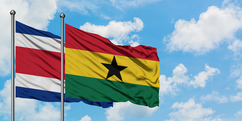 Costa Rica and Ghana flag waving in the wind against white cloudy blue sky together. Diplomacy...