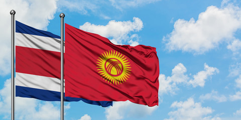 Costa Rica and Kyrgyzstan flag waving in the wind against white cloudy blue sky together. Diplomacy concept, international relations.