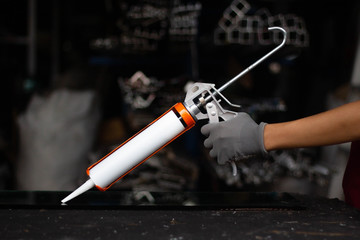 Men's hand uses silicone adhesive with adhesive to connect the mirror with aluminum.