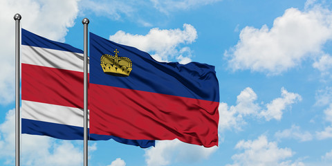 Costa Rica and Liechtenstein flag waving in the wind against white cloudy blue sky together. Diplomacy concept, international relations.