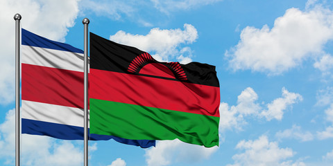 Costa Rica and Malawi flag waving in the wind against white cloudy blue sky together. Diplomacy concept, international relations.