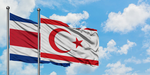 Costa Rica and Northern Cyprus flag waving in the wind against white cloudy blue sky together. Diplomacy concept, international relations.