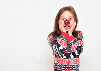 Cute little girl in pajama with a bow on her nose posing on light background.