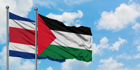 Costa Rica and Palestine flag waving in the wind against white cloudy blue sky together. Diplomacy concept, international relations.