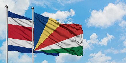 Costa Rica and Seychelles flag waving in the wind against white cloudy blue sky together. Diplomacy concept, international relations.
