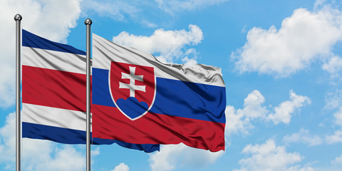 Costa Rica and Slovakia flag waving in the wind against white cloudy blue sky together. Diplomacy concept, international relations.