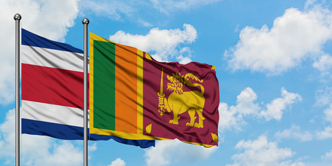 Costa Rica and Sri Lanka flag waving in the wind against white cloudy blue sky together. Diplomacy concept, international relations.