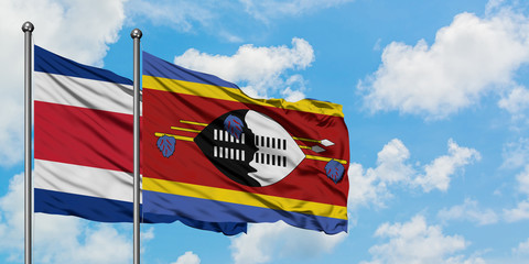 Costa Rica and Swaziland flag waving in the wind against white cloudy blue sky together. Diplomacy concept, international relations.