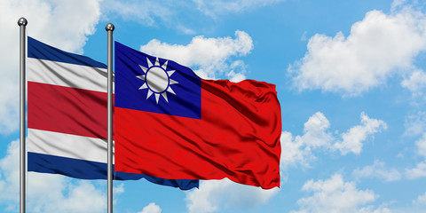 Costa Rica and Taiwan flag waving in the wind against white cloudy blue sky together. Diplomacy concept, international relations.