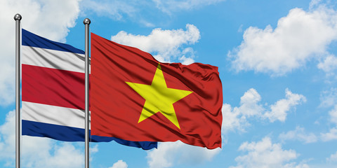 Costa Rica and Vietnam flag waving in the wind against white cloudy blue sky together. Diplomacy concept, international relations.