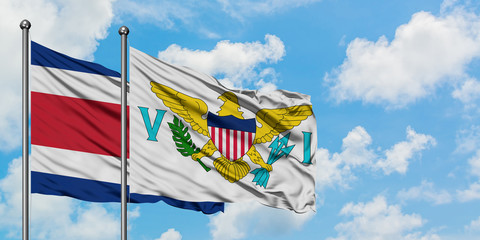 Costa Rica and United States Virgin Islands flag waving in the wind against white cloudy blue sky together. Diplomacy concept, international relations.