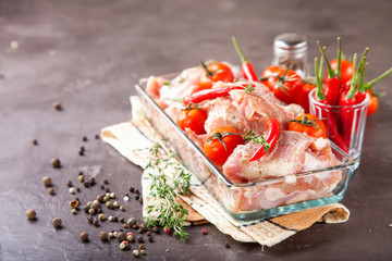 pieces of meat of chicken with tomatoes and pepper in a bowl on a table, selective focus, copy space