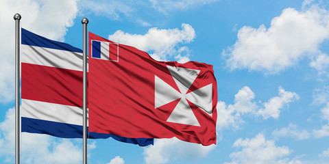 Costa Rica and Wallis And Futuna flag waving in the wind against white cloudy blue sky together. Diplomacy concept, international relations.