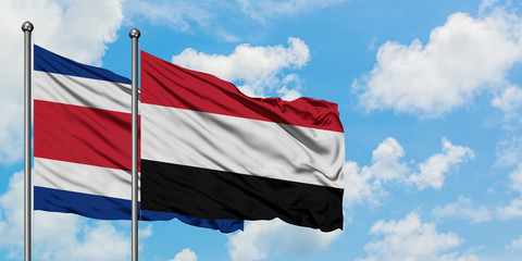 Costa Rica and Yemen flag waving in the wind against white cloudy blue sky together. Diplomacy concept, international relations.