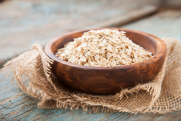 Oat flakes in a bowl on a table, selective focus, copy space