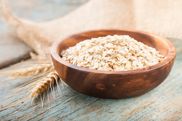 Oat flakes in a bowl on a table, selective focus, copy space