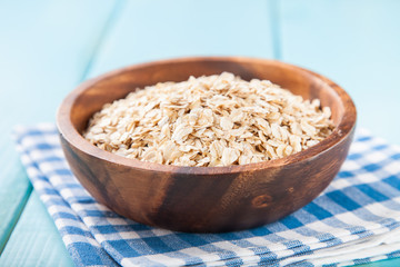 Oat flakes in a bowl on a table, selective focus, copy space