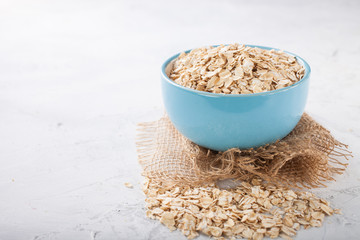 Oat flakes in a bowl on a table, selective focus, copy space