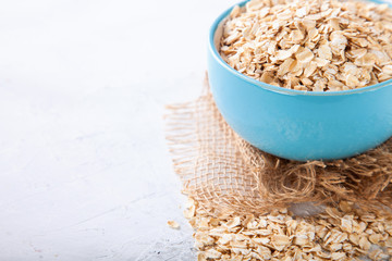 Oat flakes in a bowl on a table, selective focus, copy space