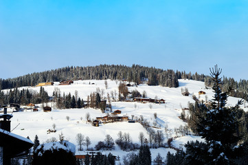 old alpine houses of a small Austrian village on top of a snowy alpine mountain