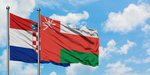 Croatia and Oman flag waving in the wind against white cloudy blue sky together. Diplomacy concept, international relations.