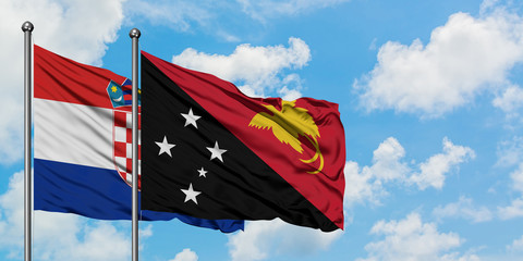 Croatia and Papua New Guinea flag waving in the wind against white cloudy blue sky together. Diplomacy concept, international relations.