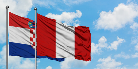 Croatia and Peru flag waving in the wind against white cloudy blue sky together. Diplomacy concept, international relations.