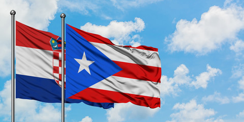 Croatia and Puerto Rico flag waving in the wind against white cloudy blue sky together. Diplomacy concept, international relations.