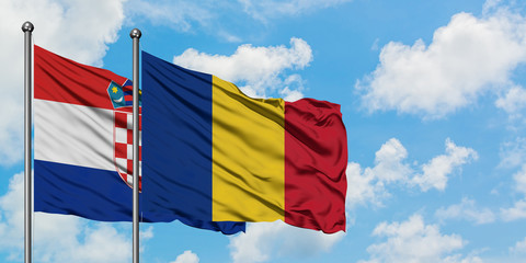 Croatia and Romania flag waving in the wind against white cloudy blue sky together. Diplomacy concept, international relations.