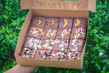 Fudge brownies in a brown paper box on hand