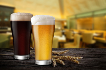 Glasses of Light Beer and Dark Beer with wheat on the bar counter in the restaurant at night, with copy space