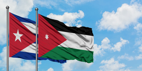 Cuba and Jordan flag waving in the wind against white cloudy blue sky together. Diplomacy concept, international relations.