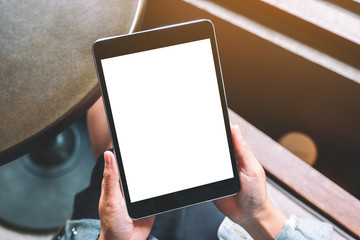 Top view mockup image of a woman holding black tablet with white blank screen