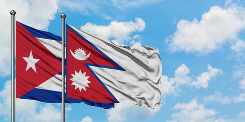 Cuba and Nepal flag waving in the wind against white cloudy blue sky together. Diplomacy concept, international relations.